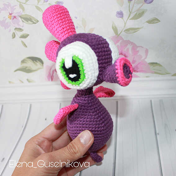 Cute seahorse amigurumi free crochet pattern held in hand, colorful handmade ocean animal toy