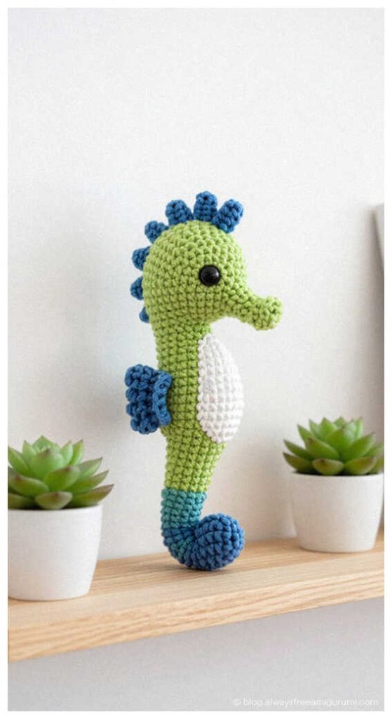 green seahorse amigurumi crochet doll standing on wooden shelf with small plants cute ocean nursery decor idea
