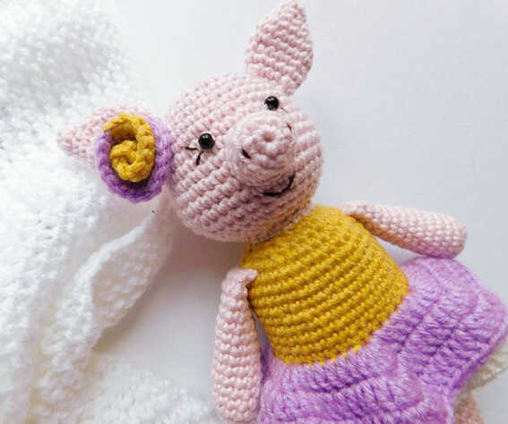 Amigurumi pig doll close up with flower detail and colorful dress, free crochet pig pattern