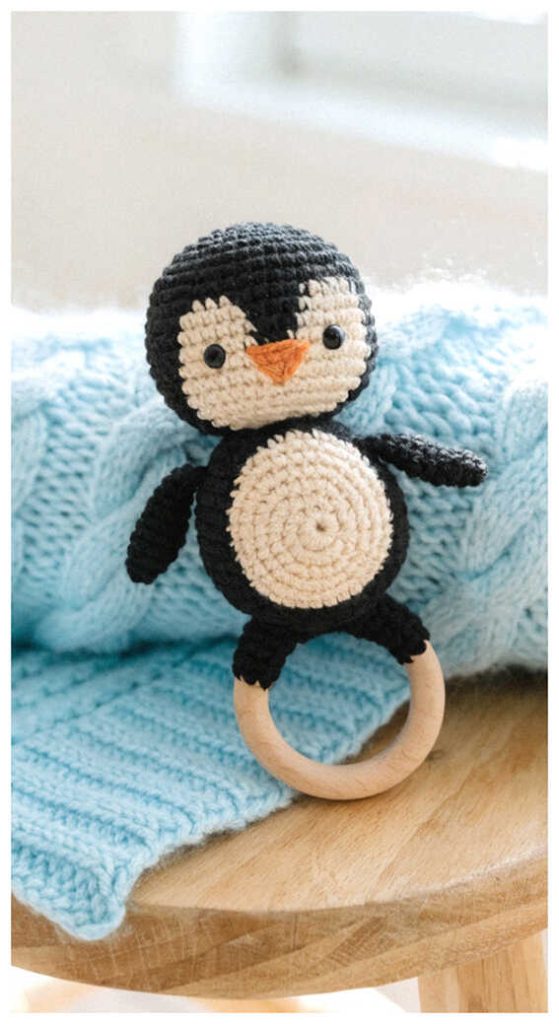 crochet penguin baby rattle with wooden ring cute handmade baby toy on soft blanket
