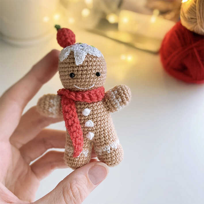 Classic gingerbread man amigurumi crochet plush toy held in hand